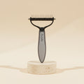 MotaCero Duo cepillo deslanador gris sobre pedestal marfil